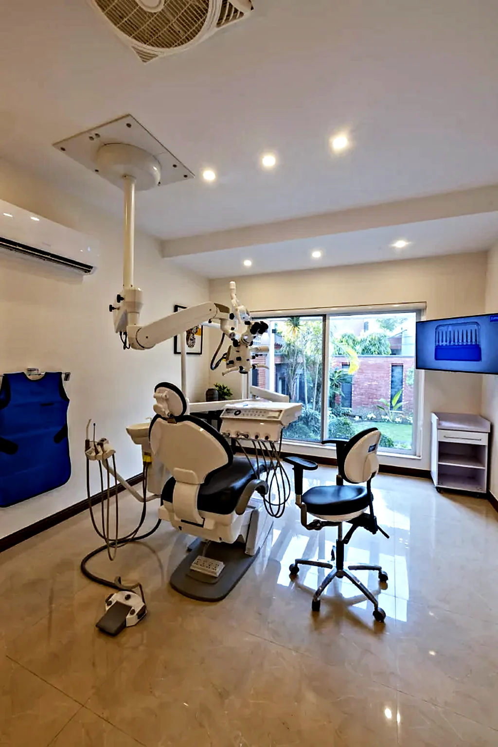 Treatment room with a ceiling-mounted surgical microscope and dental chair